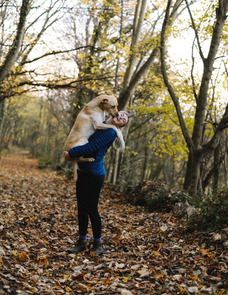 Woman hugs dog in forest